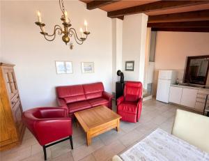a living room with red chairs and a table at Casa Ana Istria 1 in Savudrija