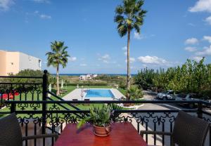 a balcony with a view of a pool and palm trees at Socrates Holidays Apt 3 with Pool near the Beach in Kamisianá