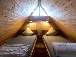 two beds in a small room with a window at Happy Hippy Cabin for 4 persons in Gataučiai +30 photos