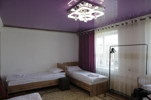 a room with two beds and a purple ceiling at Central Guest House Karakol in Karakol