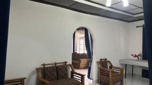 a living room with two chairs and a window at Madu Guest in Nuwara Eliya