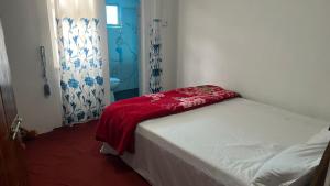 a bedroom with a bed with a red blanket on it at Madu Guest in Nuwara Eliya