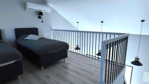 a bedroom with a bed and a balcony with a staircase at Bele Lofts in Karmėlava