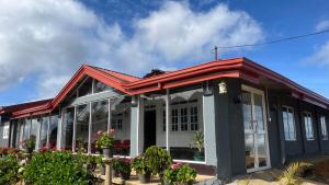 a building with a red roof and some plants at Madu Guest in Nuwara Eliya