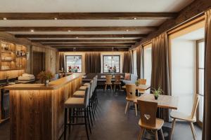 a restaurant with a bar and tables and chairs at Albergo Stella in La Villa