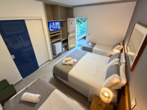a bedroom with a large bed and a television at Mar e Praia Hotel in Ubatuba +69 photos