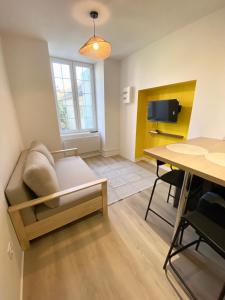 a living room with a couch and a table at Studio cosy avec jardin privé - Proche de tout ! in Montbard