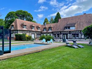 an estate with a swimming pool and a house at La Maison Maya Normandie in Saint-Éloi-de-Fourques