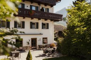 a building with tables and chairs in front of it at Albergo Stella in La Villa