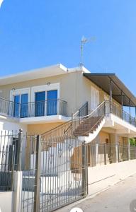 a white house with stairs in front of it at Nectar Beach House in Neokhórion
