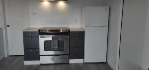 a kitchen with a stove and a refrigerator at Centennial Motel in Kindersley