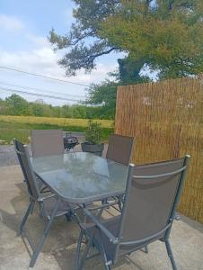 a glass table and chairs on a patio at Charmante maison à louer in Lagor