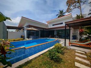 a swimming pool in front of a house at Beautiful accommodation on Lipa Noi in Nathon Bay