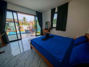a bedroom with a blue bed and a view of a pool at Beautiful accommodation on Lipa Noi in Nathon Bay +29 photos