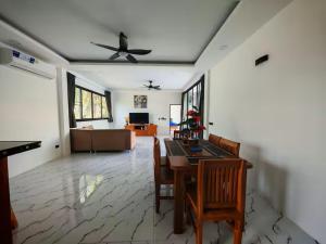 a living room with a table and a ceiling fan at Beautiful accommodation on Lipa Noi in Nathon Bay