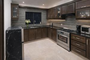 a kitchen with wooden cabinets and a black counter top at Hotel White Castle Islamabad in Islamabad