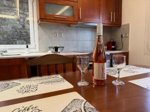 a bottle of wine sitting on a table with two glasses at Leka Village Our Hidden Gem in Léka +12 photos