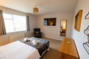 a bedroom with a bed and a chair and a mirror at Havrock in Orkney