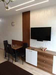 a dining room with a table and a television on a wall at ევრო პალას გონიო in Kvariati