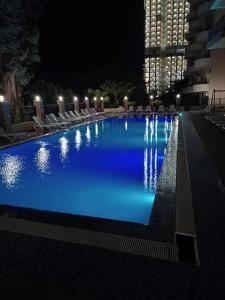 a large swimming pool at night with blue lighting at ევრო პალას გონიო in Kvariati