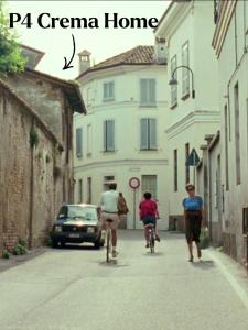 a group of people riding bikes down a street at P4 Crema Home in Crema
