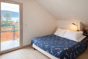 a bedroom with a bed and a large window at L 'Écrin du Lac et Parkings in Veyrier-du-Lac