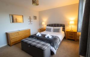 a bedroom with a bed and a ottoman in it at Havrock in Orkney