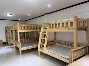 a group of wooden bunk beds in a room at FUBON World Hostel in Ban That-Louang