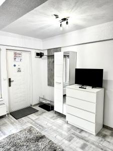 a room with a white dresser and a tv at NextSpace Nr 2 in Sfântu-Gheorghe