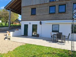 eine Terrasse mit Tisch und Stühlen vor einem Haus in der Unterkunft Studio Keppelborn in Sankt Vith