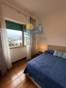 a bedroom with a blue bed and a large window at Etruscan Blue House in Piombino