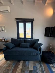 a blue couch in a living room with a window at The Dona House in Vaia