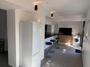 a kitchen with a white refrigerator and two stools at sologne detente in Souesmes