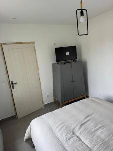 a bedroom with a bed and a tv and a door at sologne detente in Souesmes