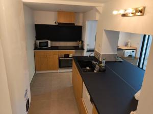 a kitchen with a black counter top and a microwave at sologne detente in Souesmes
