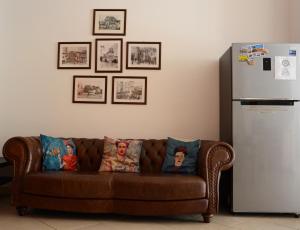 a brown couch sitting in a living room next to a refrigerator at The Rock Hostel in Matera