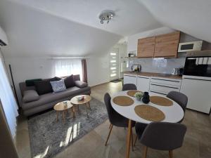 a kitchen and a living room with a table and chairs at Velebitska Vila in Gračac