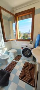 a bathroom with a toilet and a washing machine at Abate Appartament in Correzzola +20 photos