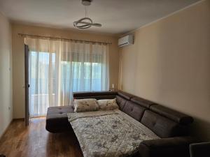 a living room with a couch and a large window at Elena Residence 15min from Belgrade in Pančevo