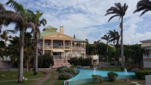 a large house with a swimming pool and palm trees at Our dream in blue in Sèze