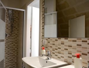 a bathroom with a sink and a mirror at The Rock Hostel in Matera