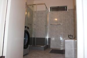 a shower in a bathroom with a washing machine at Thami residence - Self catering in Grahamstown