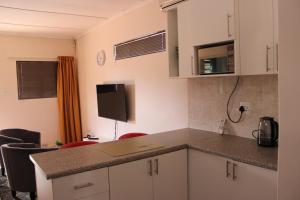 a kitchen with white cabinets and a counter top at Thami residence - Self catering in Grahamstown
