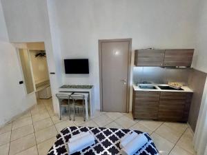 a small kitchen with a table and a bed in a room at Tuanis in Naples