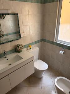 a bathroom with a toilet and a sink and a mirror at Rosa dei venti 3 in Santa Maria