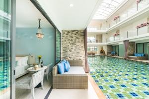a hotel pool with a bed and a table and chairs at My Vimarn Hua Hin in Hua Hin