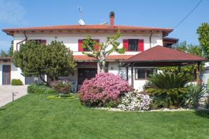 a house with a yard with flowers in front of it at GinKgo B&B in Francavilla al Mare
