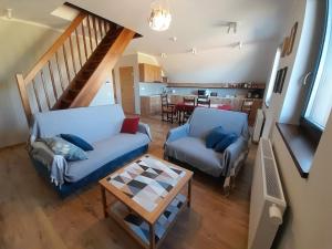 a living room with a couch and a table at Apartament Blisko Lasu in Rzystnowo