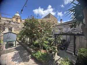 a garden with flowers and plants in front of a building at B&B Giardino Incantato in Piazza Armerina
