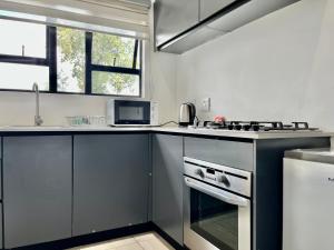 a kitchen with a sink and a stove top oven at No 6 On Cladon # Jadde Apartments in Chartwell